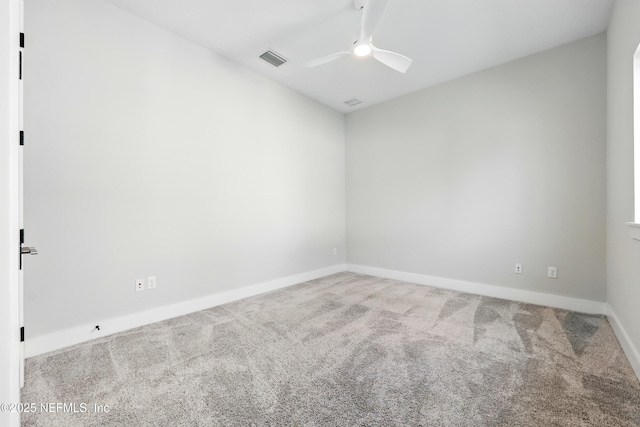 carpeted empty room with a ceiling fan and baseboards