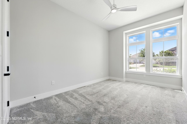 carpeted empty room with baseboards and ceiling fan