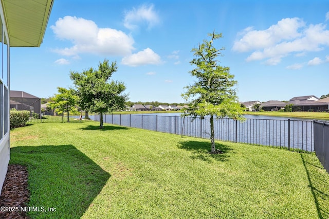 view of yard featuring a residential view and a water view