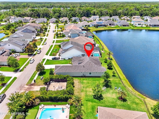 aerial view of residential area featuring a nearby body of water and a pool