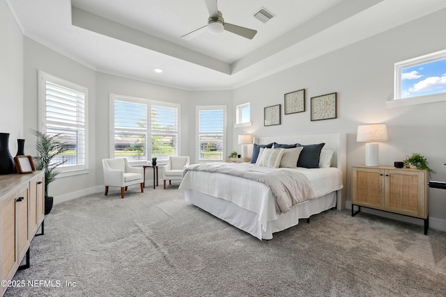 carpeted bedroom featuring a tray ceiling, baseboards, and ceiling fan