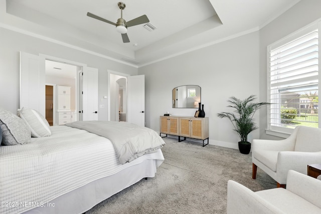 carpeted bedroom featuring a raised ceiling, ceiling fan, arched walkways, and baseboards