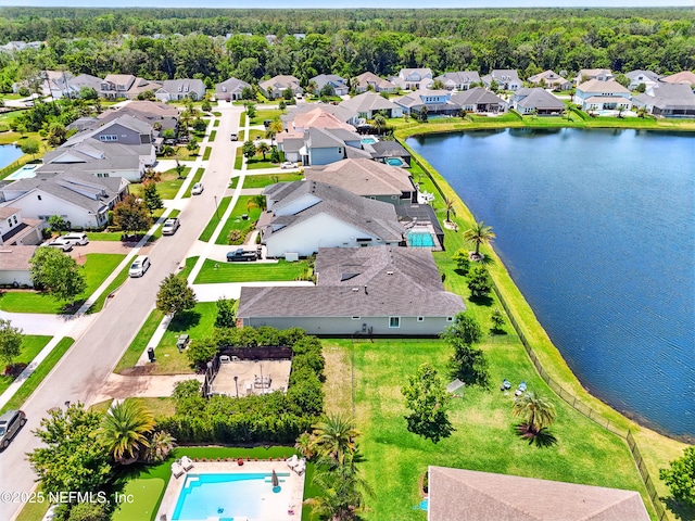 aerial view of residential area featuring a nearby body of water and a pool area