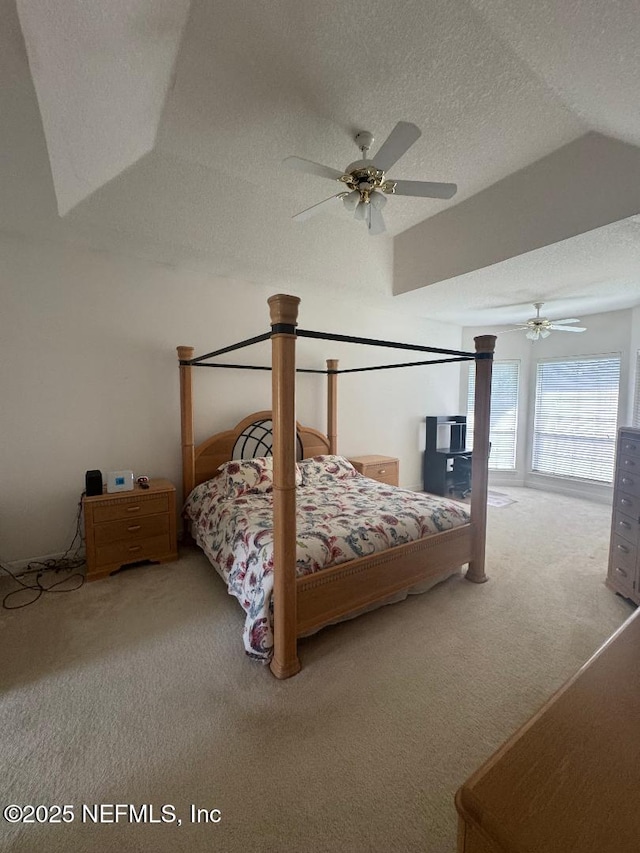 carpeted bedroom featuring a textured ceiling, a ceiling fan, and vaulted ceiling