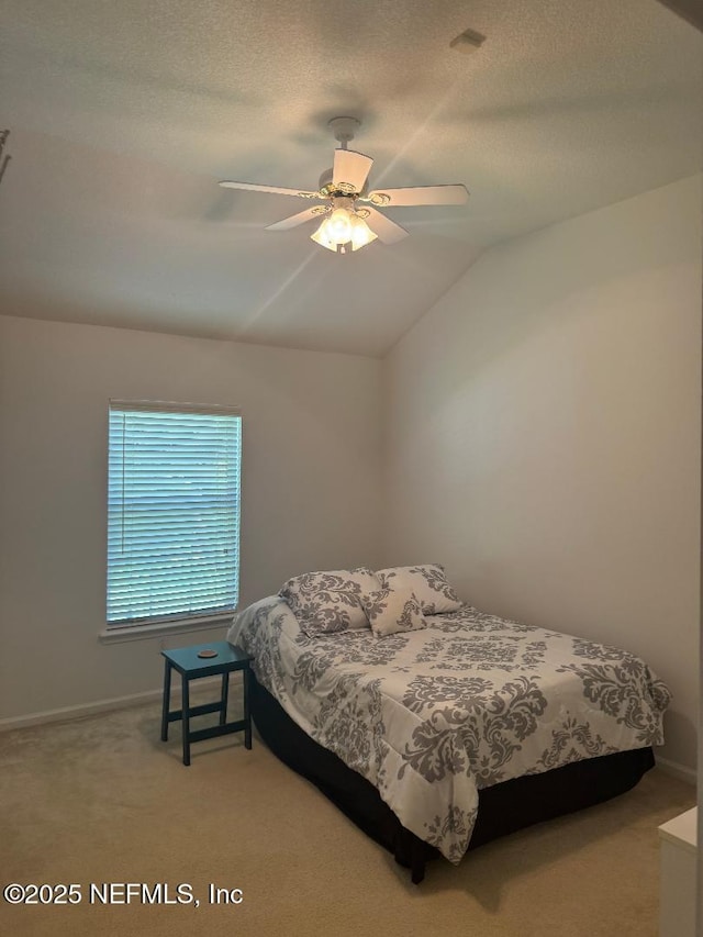 bedroom featuring light carpet, baseboards, lofted ceiling, and a ceiling fan