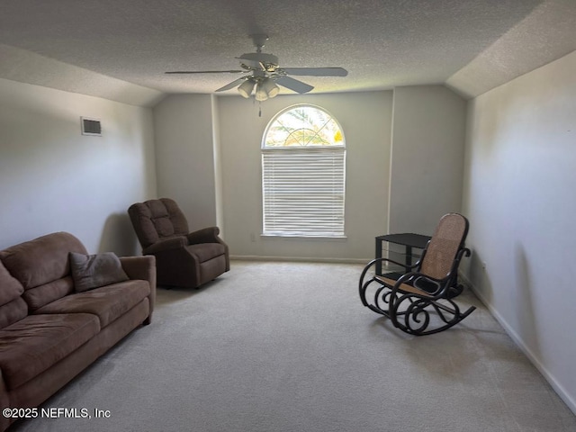 living area featuring lofted ceiling, ceiling fan, a textured ceiling, carpet, and baseboards
