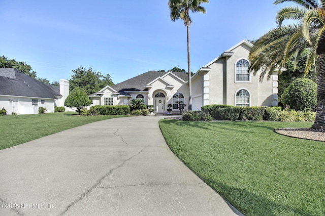 809 Lotus Ln N, Fruit Cove, FL 32259 - view of front of property with concrete driveway, a front lawn, a garage, and stucco siding