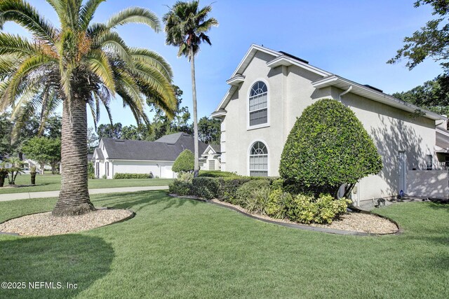 809 Lotus Ln N, Fruit Cove, FL 32259 - view of side of property featuring stucco siding and a yard
