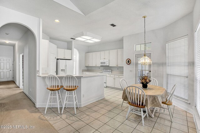 809 Lotus Ln N, Fruit Cove, FL 32259 - kitchen featuring white appliances, a peninsula, white cabinets, a breakfast bar, and light countertops