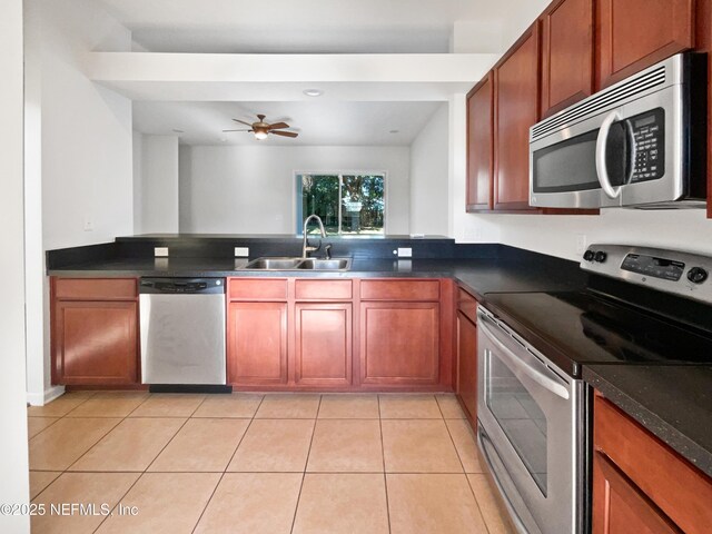 3020 Southbank Cir, Green Cove Springs, FL 32043 - kitchen featuring stainless steel appliances, a sink, dark countertops, and light tile patterned floors