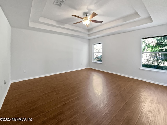 3020 Southbank Cir, Green Cove Springs, FL 32043 - unfurnished room featuring a tray ceiling, ceiling fan, dark wood-style floors, and baseboards