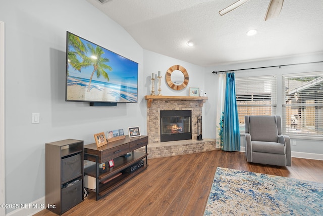 1770 High Brook Ct, Jacksonville, FL 32225 - living room with wood finished floors, a brick fireplace, a textured ceiling, ceiling fan, and baseboards