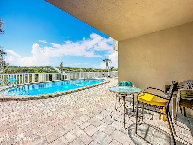 view of pool with a patio and fence