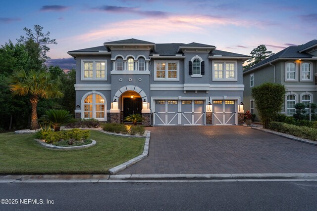 135 Tate Ln, Saint Johns, FL 32259 - view of front of property with a garage, stucco siding, decorative driveway, a front lawn, and stone siding