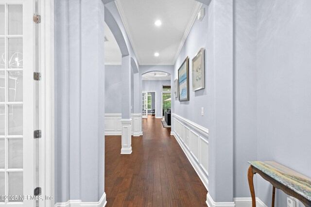 135 Tate Ln, Saint Johns, FL 32259 - corridor featuring arched walkways, crown molding, a wainscoted wall, dark wood-type flooring, and a decorative wall