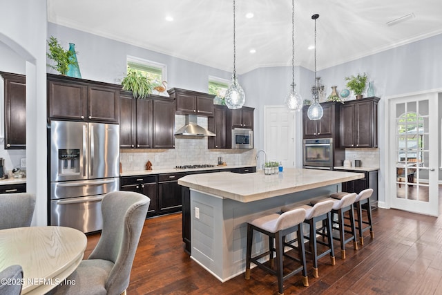 135 Tate Ln, Saint Johns, FL 32259 - kitchen with appliances with stainless steel finishes, wall chimney exhaust hood, a kitchen breakfast bar, crown molding, and backsplash