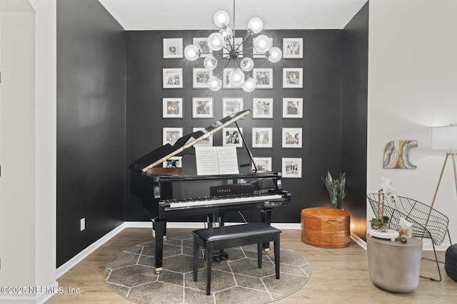 living area featuring wood finished floors, a chandelier, and baseboards