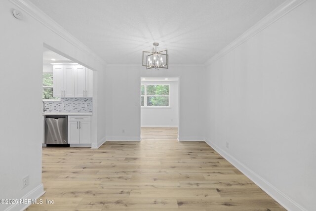 7420 Mayapple Rd, Jacksonville, FL 32211 - unfurnished dining area with a chandelier, plenty of natural light, ornamental molding, light wood-style floors, and baseboards