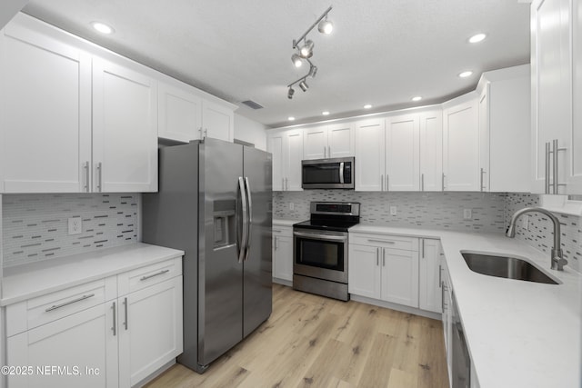 7420 Mayapple Rd, Jacksonville, FL 32211 - kitchen featuring stainless steel appliances, a sink, white cabinetry, light countertops, and light wood-type flooring