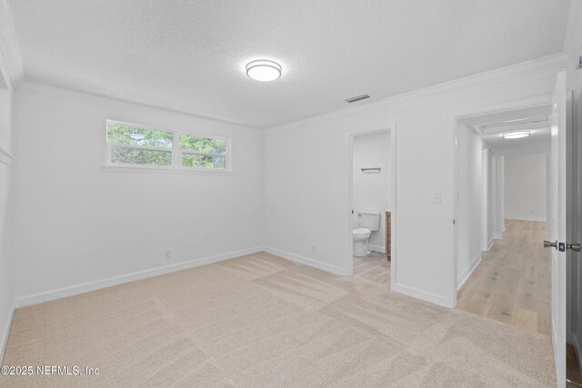 7420 Mayapple Rd, Jacksonville, FL 32211 - unfurnished bedroom with light carpet, ornamental molding, baseboards, a textured ceiling, and ensuite bath