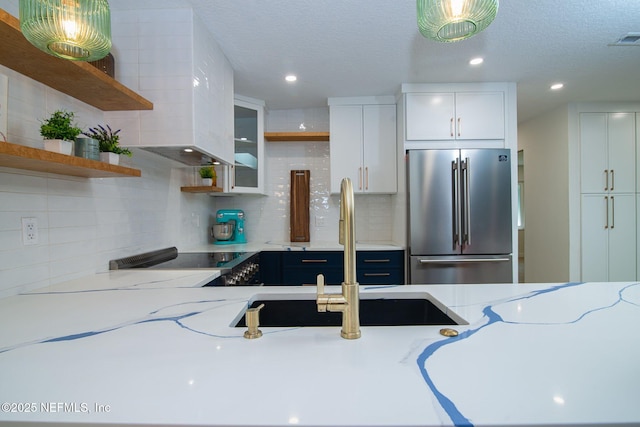 77 Sanchez Dr E, Ponte Vedra Beach, FL 32082 - kitchen with high end fridge, open shelves, a sink, tasteful backsplash, and white cabinets