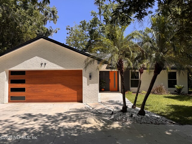 77 Sanchez Dr E, Ponte Vedra Beach, FL 32082 - view of front of home with brick siding, an attached garage, driveway, and a front lawn