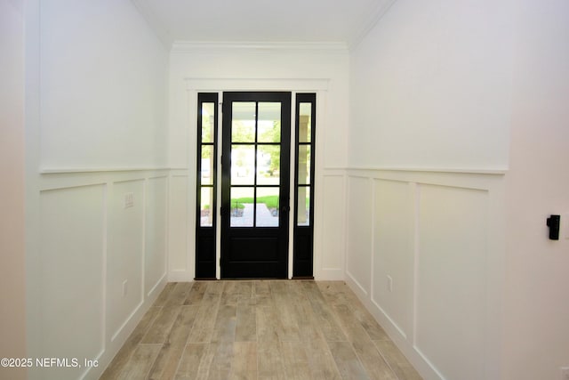 95121 N Ellis Landing Rd, Fernandina Beach, FL 32034 - foyer featuring a decorative wall, light wood-style floors, ornamental molding, and a wainscoted wall