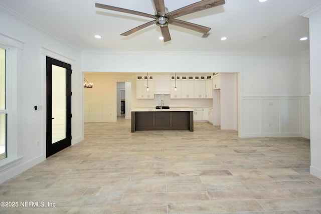 95121 N Ellis Landing Rd, Fernandina Beach, FL 32034 - unfurnished living room with a sink, a decorative wall, crown molding, light wood-type flooring, and recessed lighting
