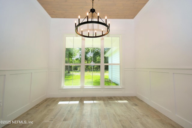 95121 N Ellis Landing Rd, Fernandina Beach, FL 32034 - unfurnished dining area featuring a decorative wall, a chandelier, ornamental molding, wood ceiling, and light wood-style flooring