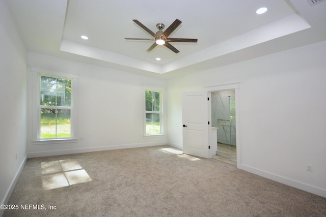 95121 N Ellis Landing Rd, Fernandina Beach, FL 32034 - empty room featuring a raised ceiling, ceiling fan, carpet flooring, baseboards, and healthy amount of natural light