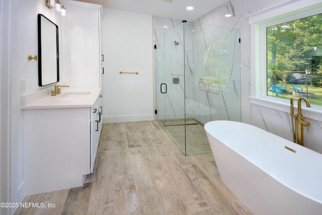 95121 N Ellis Landing Rd, Fernandina Beach, FL 32034 - full bathroom featuring vanity, a marble finish shower, wood finished floors, a freestanding tub, and recessed lighting
