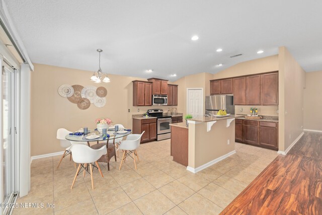 467 S Aberdeenshire Dr, Saint Johns, FL 32259 - kitchen with appliances with stainless steel finishes, baseboards, a breakfast bar, light countertops, and lofted ceiling