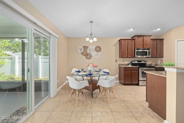 467 S Aberdeenshire Dr, Saint Johns, FL 32259 - kitchen featuring appliances with stainless steel finishes, a chandelier, baseboards, hanging light fixtures, and light tile patterned flooring