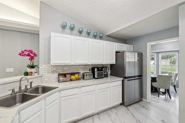 3100 Hickory Glen Dr, Orange Park, FL 32065 - kitchen with freestanding refrigerator, a sink, white cabinetry, a textured ceiling, and tasteful backsplash