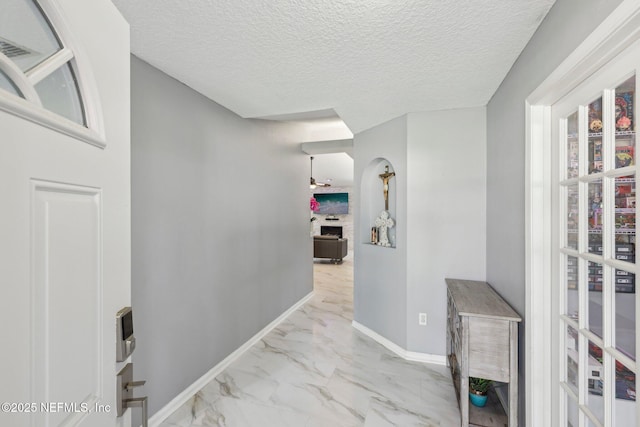 3100 Hickory Glen Dr, Orange Park, FL 32065 - hallway with marble look tile flooring, baseboards, and a textured ceiling