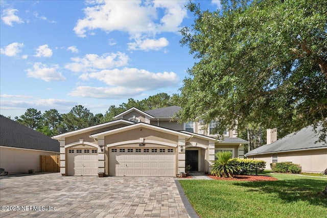 8719 Derry Dr, Jacksonville, FL 32244 - view of front facade with decorative driveway, a garage, stucco siding, and a front yard