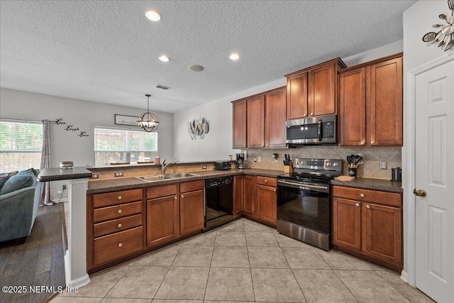 8719 Derry Dr, Jacksonville, FL 32244 - kitchen with black appliances, a peninsula, a sink, dark countertops, and a textured ceiling