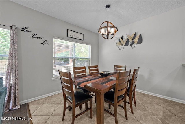 8719 Derry Dr, Jacksonville, FL 32244 - dining room featuring a chandelier, a textured ceiling, light tile patterned flooring, and baseboards