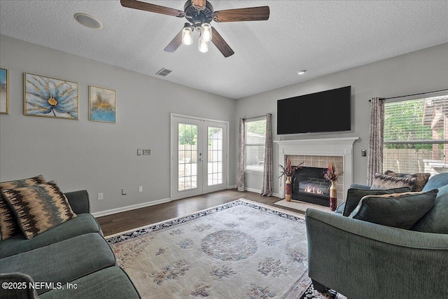 8719 Derry Dr, Jacksonville, FL 32244 - living room featuring baseboards, a ceiling fan, a textured ceiling, wood finished floors, and a tile fireplace