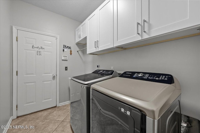 8719 Derry Dr, Jacksonville, FL 32244 - laundry area featuring washer and dryer, cabinet space, baseboards, light tile patterned floors, and a textured ceiling