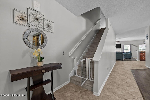 8719 Derry Dr, Jacksonville, FL 32244 - stairs with a textured ceiling, baseboards, and tile patterned floors
