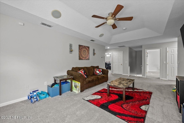8719 Derry Dr, Jacksonville, FL 32244 - carpeted living room featuring a ceiling fan, a tray ceiling, baseboards, and a textured ceiling