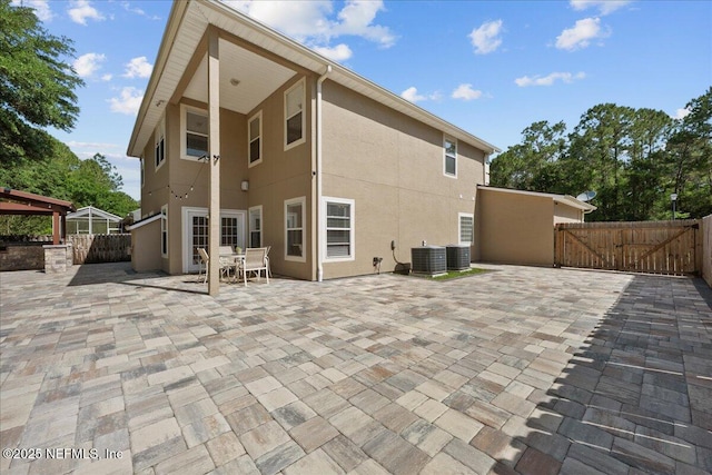 8719 Derry Dr, Jacksonville, FL 32244 - rear view of property with stucco siding, a patio, a gate, and fence