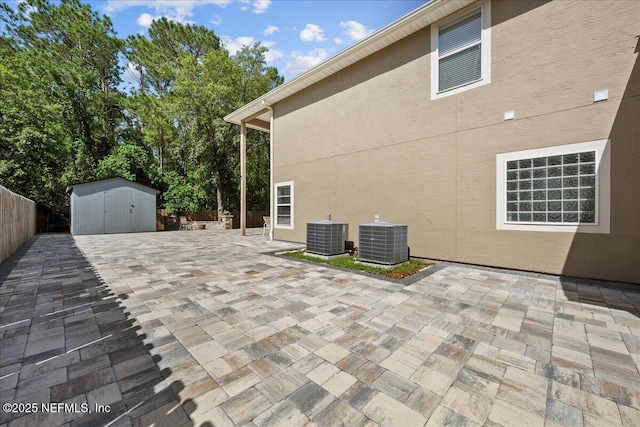 8719 Derry Dr, Jacksonville, FL 32244 - view of patio with central AC unit, a storage shed, a fenced backyard, and an outdoor structure