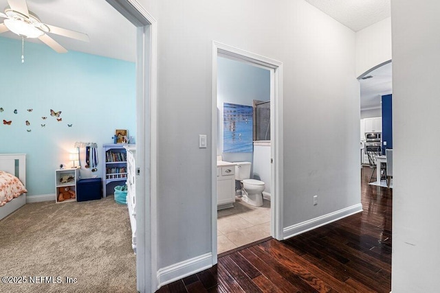 2035 Arden Forest Pl, Fleming Island, FL 32003 - bedroom with hardwood / wood-style flooring, baseboards, arched walkways, lofted ceiling, and connected bathroom