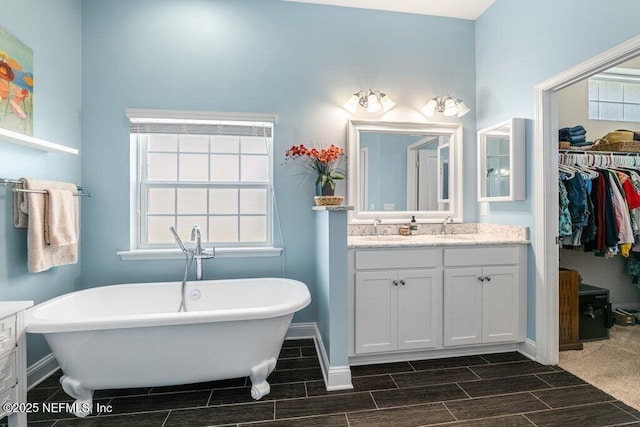 2035 Arden Forest Pl, Fleming Island, FL 32003 - full bath with wood finish floors, baseboards, vanity, a freestanding tub, and a spacious closet