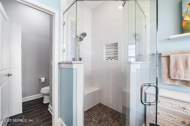 2035 Arden Forest Pl, Fleming Island, FL 32003 - full bathroom featuring a stall shower, toilet, wood finish floors, and baseboards