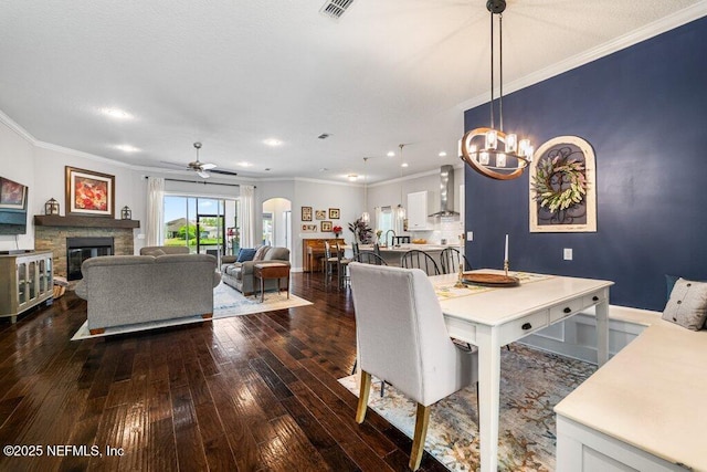 2035 Arden Forest Pl, Fleming Island, FL 32003 - dining area featuring ornamental molding, dark wood-style flooring, a fireplace, ceiling fan, and a chandelier