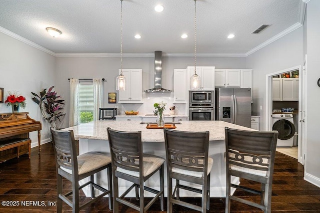 2035 Arden Forest Pl, Fleming Island, FL 32003 - kitchen with appliances with stainless steel finishes, wall chimney range hood, washer / dryer, a large island, and a textured ceiling