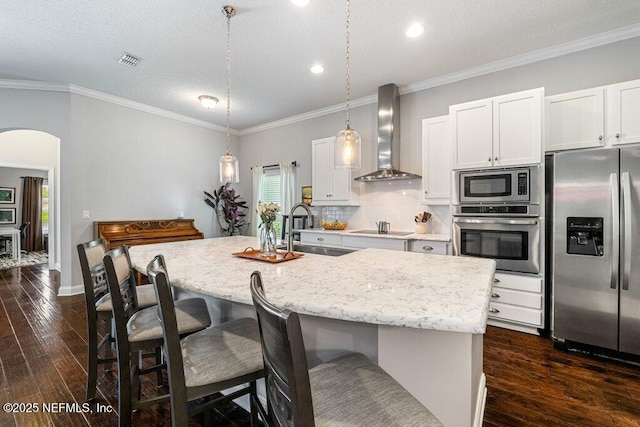 2035 Arden Forest Pl, Fleming Island, FL 32003 - kitchen with appliances with stainless steel finishes, wall chimney range hood, a sink, arched walkways, and dark wood finished floors